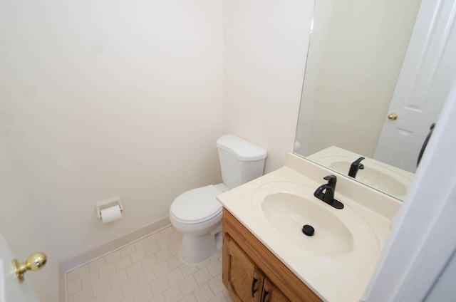 bathroom featuring toilet, tile patterned floors, baseboards, and vanity