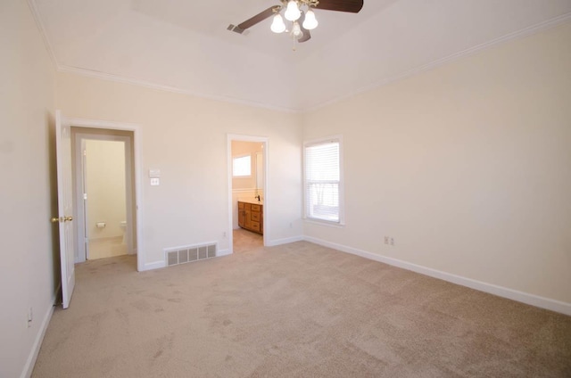 unfurnished bedroom with light carpet, visible vents, baseboards, ornamental molding, and a raised ceiling