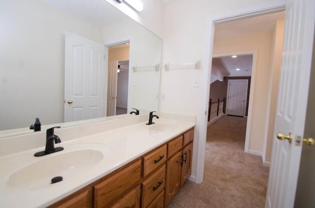 bathroom featuring double vanity, a sink, and baseboards