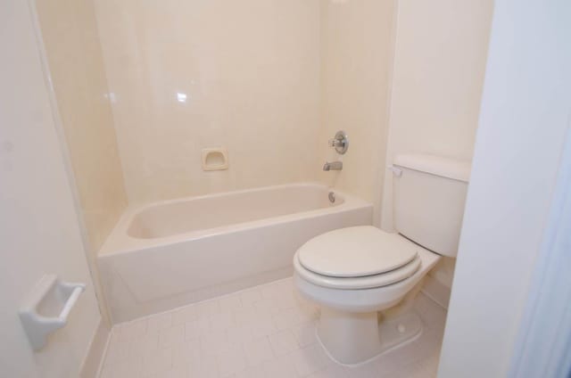 bathroom featuring tile patterned flooring, shower / tub combination, and toilet