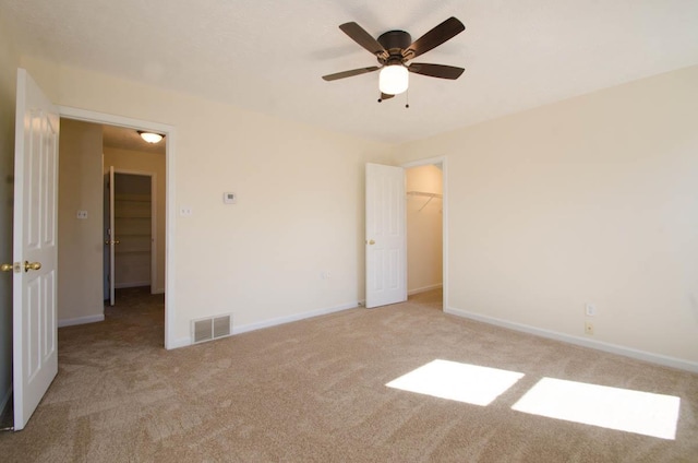 spare room with a ceiling fan, carpet, visible vents, and baseboards