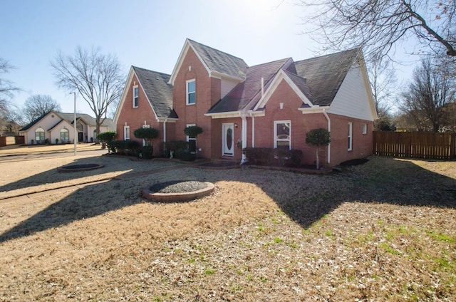 view of front of house with brick siding and fence