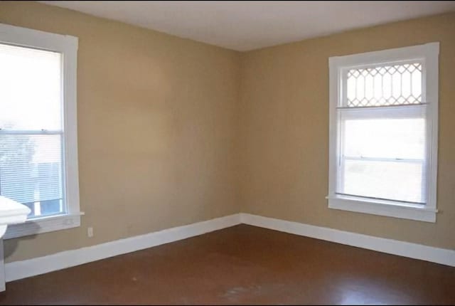 empty room with a wealth of natural light and baseboards