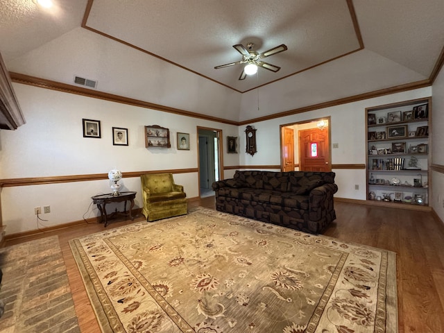 living room featuring lofted ceiling, visible vents, crown molding, and wood finished floors