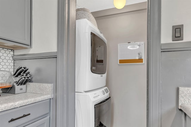 washroom with laundry area and stacked washer / drying machine