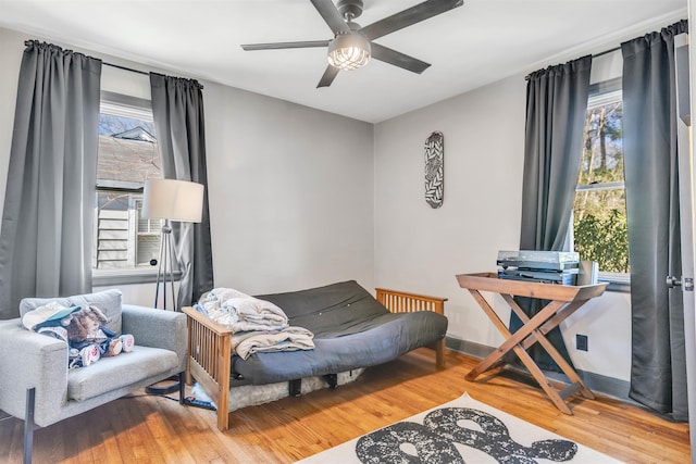 sitting room with ceiling fan, baseboards, and wood finished floors