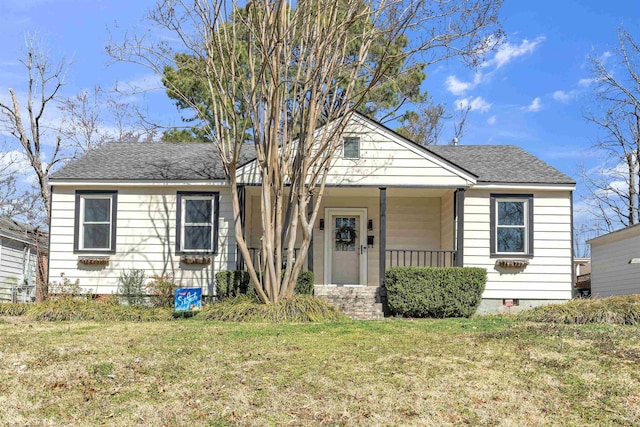 bungalow featuring a shingled roof, crawl space, covered porch, and a front lawn