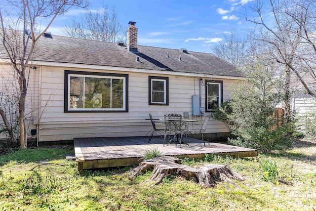 back of property featuring a shingled roof, a chimney, and a wooden deck