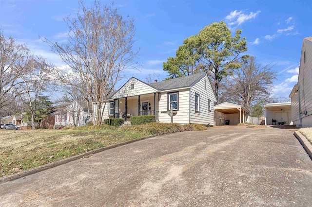 bungalow-style house with driveway, roof with shingles, a porch, and a detached carport