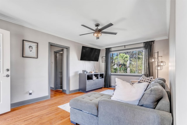 living room featuring light wood-type flooring, ceiling fan, baseboards, and crown molding