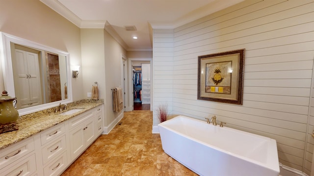 full bath with recessed lighting, vanity, a freestanding bath, a spacious closet, and ornamental molding