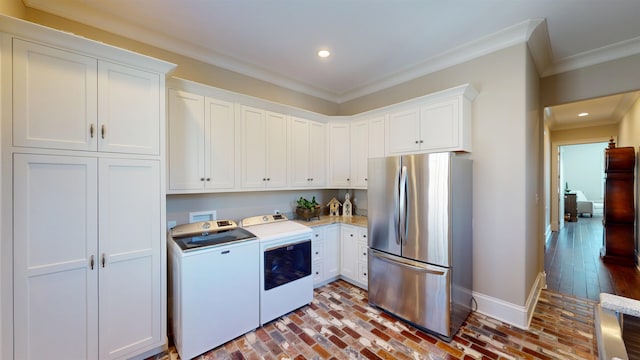 kitchen with crown molding, white cabinetry, freestanding refrigerator, and washer and dryer