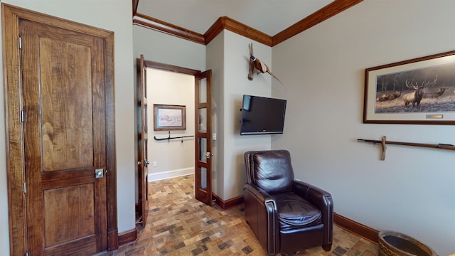 sitting room with ornamental molding, brick floor, and baseboards