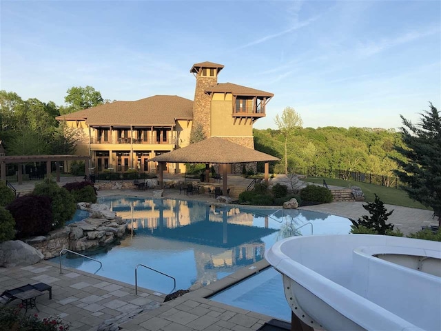 pool featuring a patio area, a hot tub, and a gazebo