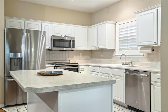 kitchen with white cabinetry, appliances with stainless steel finishes, backsplash, and a sink