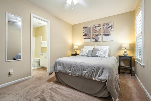 carpeted bedroom featuring multiple windows, visible vents, baseboards, and ensuite bathroom