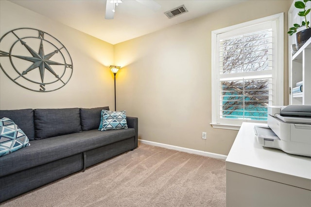 living area featuring light carpet, a ceiling fan, visible vents, and baseboards