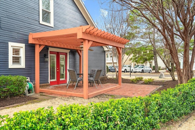 deck featuring french doors, a patio area, and a pergola