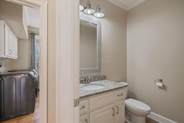 half bathroom featuring ornamental molding, vanity, toilet, and baseboards