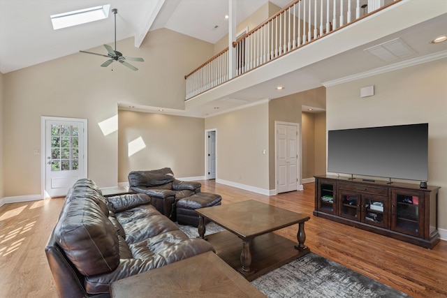 living room featuring a skylight, wood finished floors, and baseboards