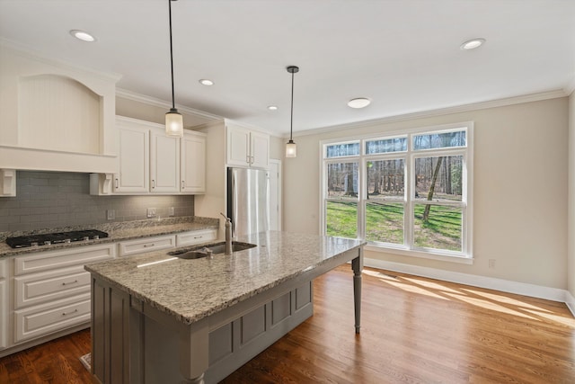 kitchen featuring dark wood-style flooring, a sink, appliances with stainless steel finishes, tasteful backsplash, and crown molding