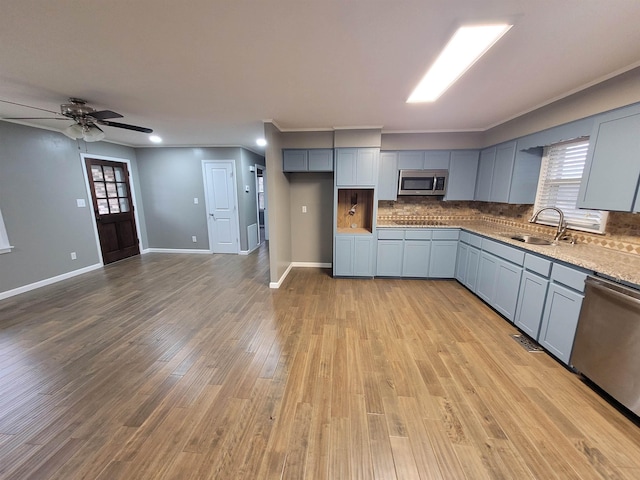 kitchen featuring tasteful backsplash, gray cabinets, and stainless steel appliances