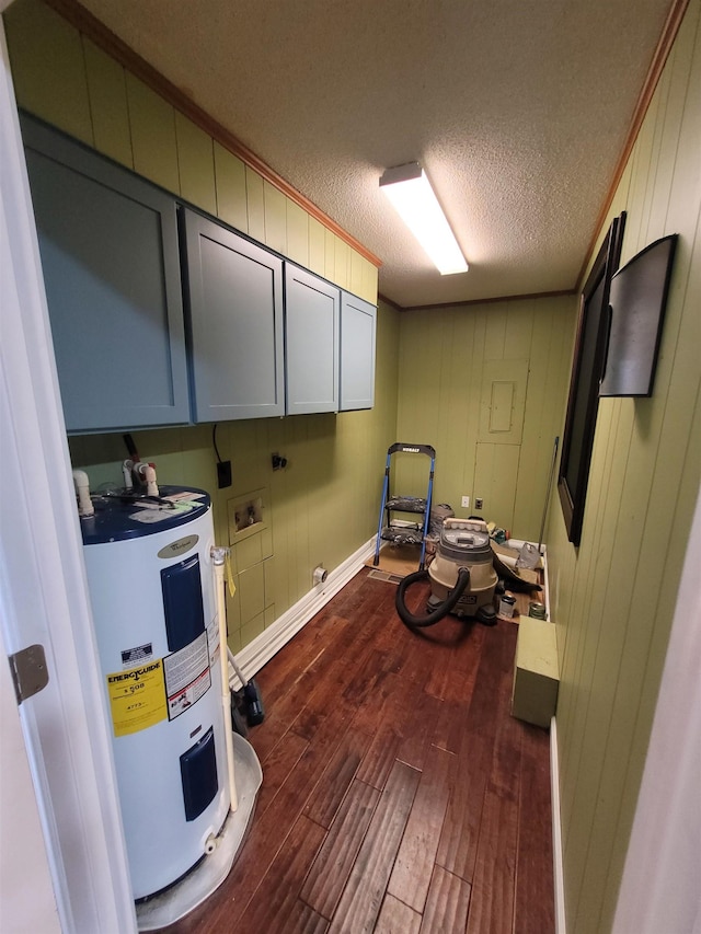 clothes washing area with cabinet space, dark wood-type flooring, electric water heater, hookup for a washing machine, and a textured ceiling