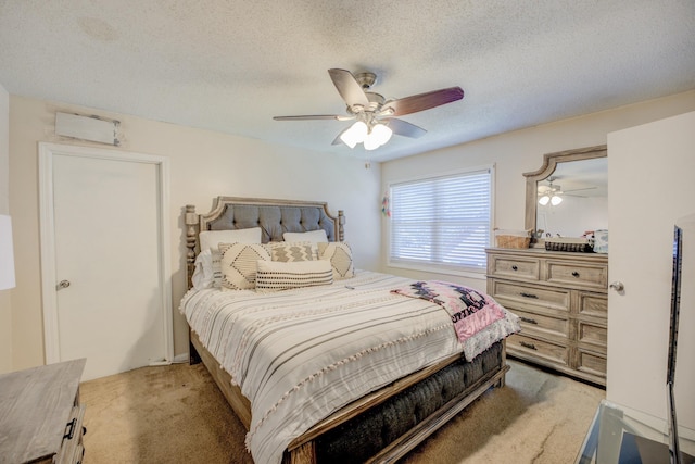 bedroom featuring a textured ceiling, a ceiling fan, and light colored carpet