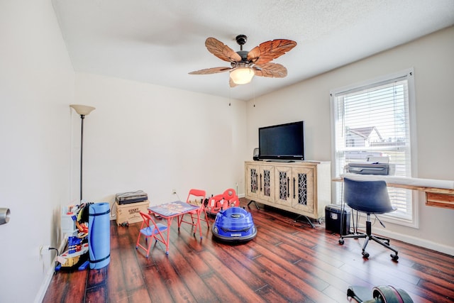 playroom featuring a ceiling fan, a wealth of natural light, baseboards, and wood finished floors