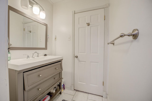 bathroom featuring tile patterned flooring, crown molding, and vanity