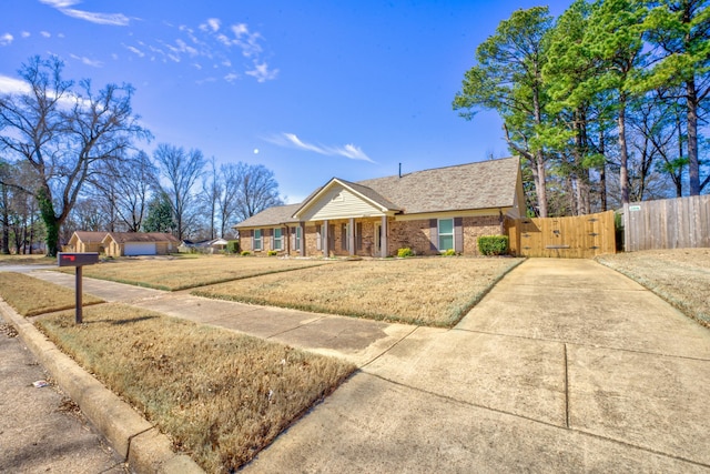 view of front of home with brick siding, fence, and a gate