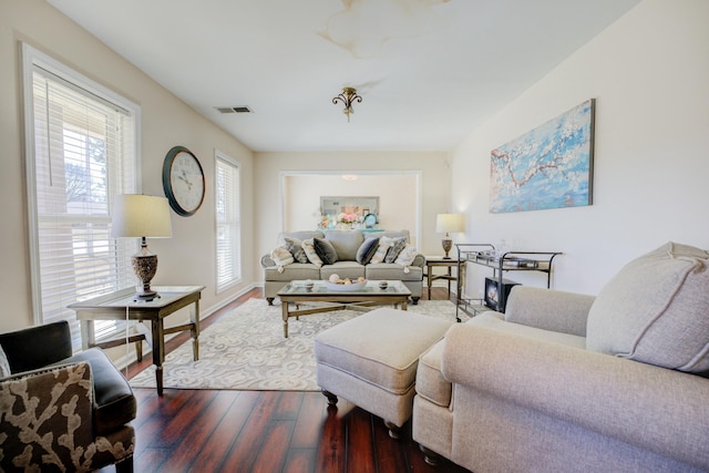 living room with dark wood-style flooring and visible vents