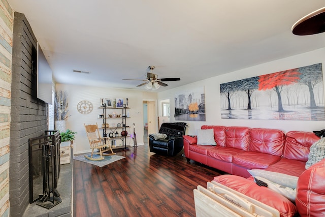 living area featuring a fireplace, wood finished floors, visible vents, and a ceiling fan