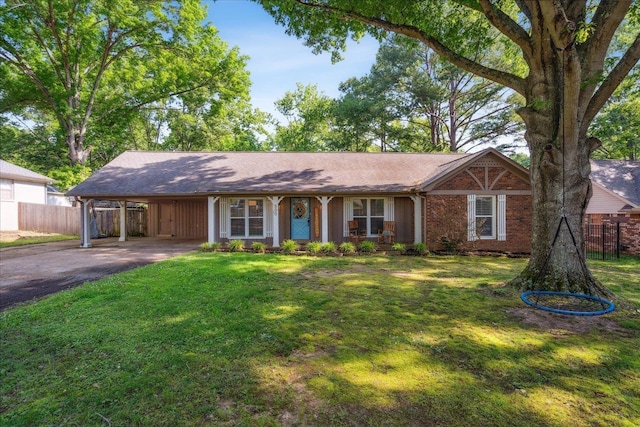 ranch-style home featuring brick siding, fence, driveway, and a front lawn