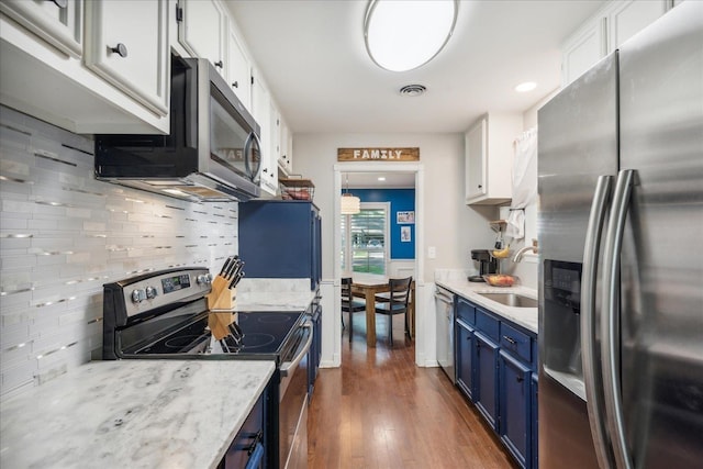 kitchen featuring visible vents, appliances with stainless steel finishes, white cabinetry, a sink, and blue cabinets