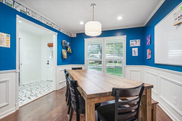 dining space featuring dark wood-style floors, recessed lighting, crown molding, and wainscoting