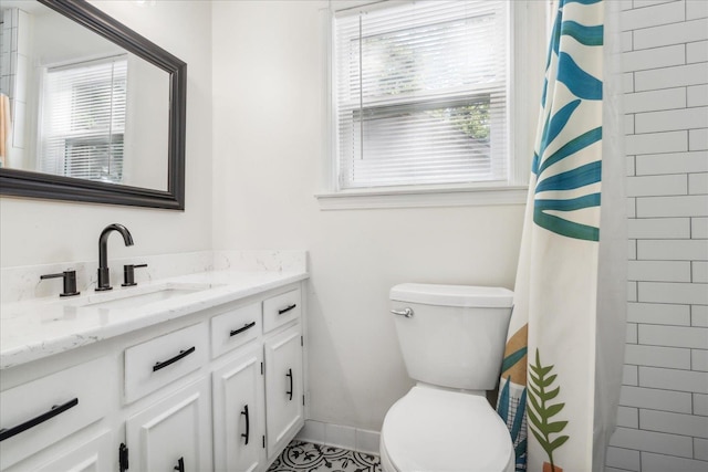 bathroom with a shower with shower curtain, baseboards, vanity, and toilet