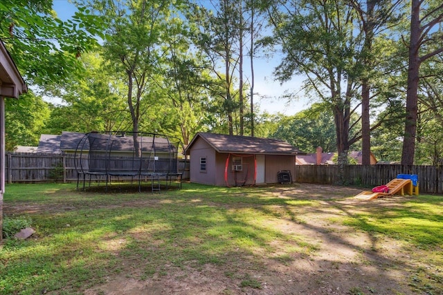 view of yard with a trampoline, a fenced backyard, and an outdoor structure