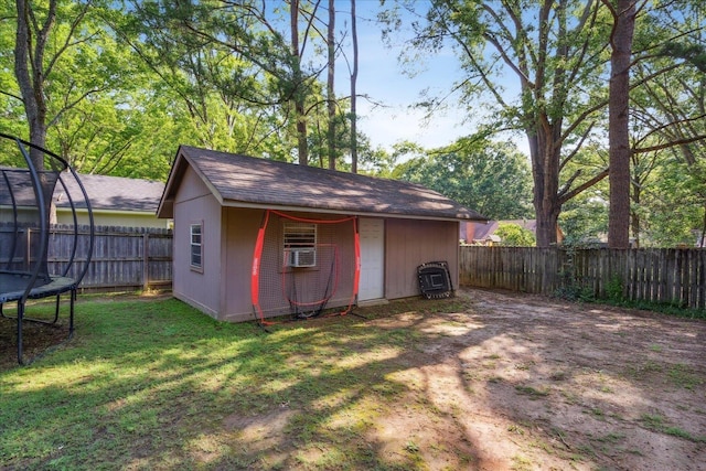 view of shed with a fenced backyard, a trampoline, and cooling unit