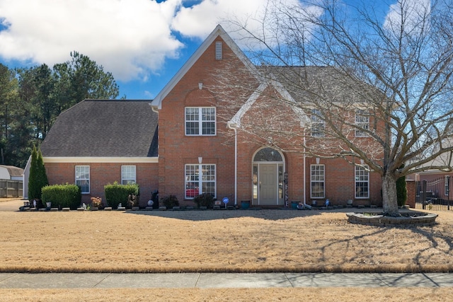 view of front of house featuring roof with shingles and brick siding