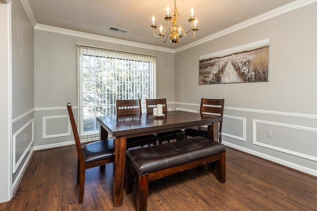 dining space with a textured ceiling, wood finished floors, visible vents, and a notable chandelier