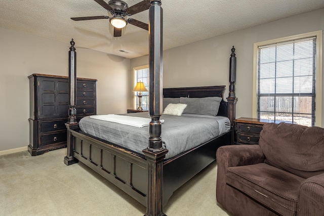 bedroom featuring a textured ceiling, light colored carpet, visible vents, baseboards, and a ceiling fan