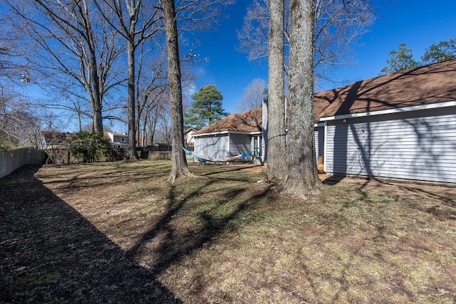 view of yard featuring fence and an outbuilding