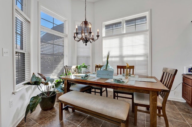 dining room featuring baseboards, a notable chandelier, and dark tile patterned flooring