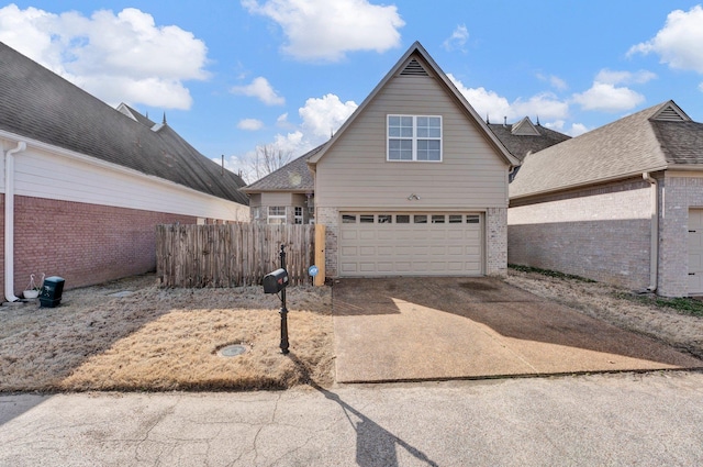 view of front facade with driveway, an attached garage, fence, and brick siding