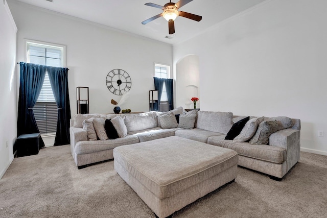 living room featuring arched walkways, light colored carpet, visible vents, a ceiling fan, and crown molding