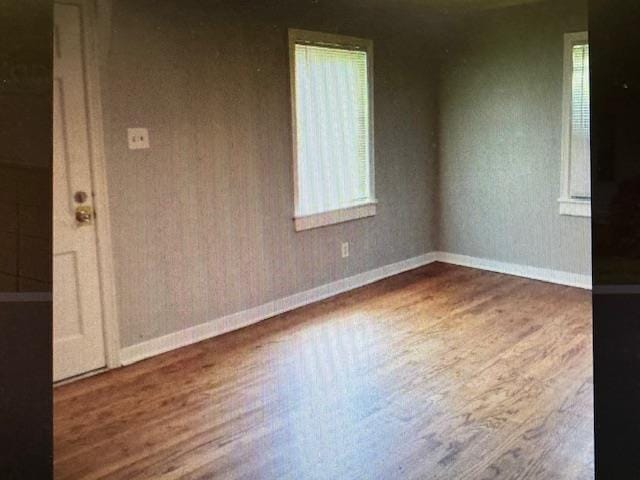 unfurnished room featuring baseboards and wood finished floors