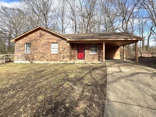 ranch-style house featuring driveway, a carport, and brick siding