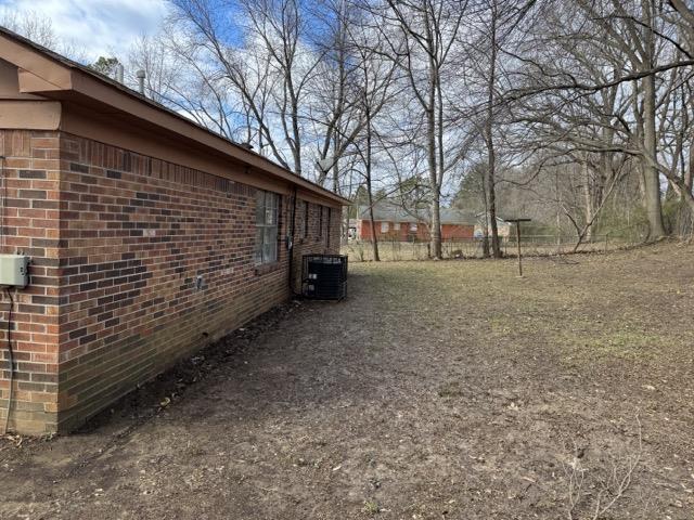 view of yard featuring central air condition unit and fence