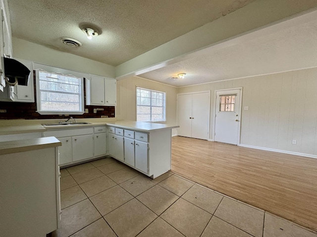 kitchen with light tile patterned floors, visible vents, light countertops, and a wealth of natural light